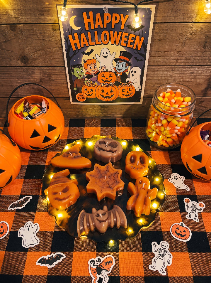 Spellbound Halloween candle set on an LED resin stand, displayed on an orange checkered table with pumpkin buckets and sweets.