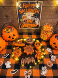 Spellbound Halloween candle set on an LED resin stand, displayed on an orange checkered table with pumpkin buckets and sweets.