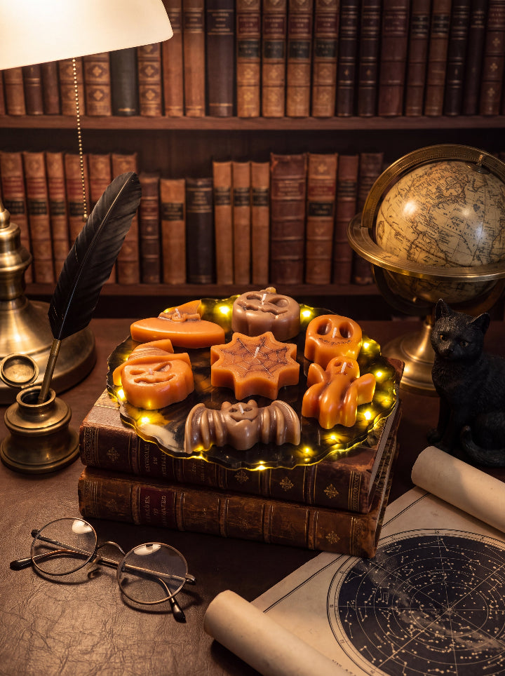 Spellbound Halloween candles on an LED resin stand atop vintage books, beside a globe, quill and star chart.