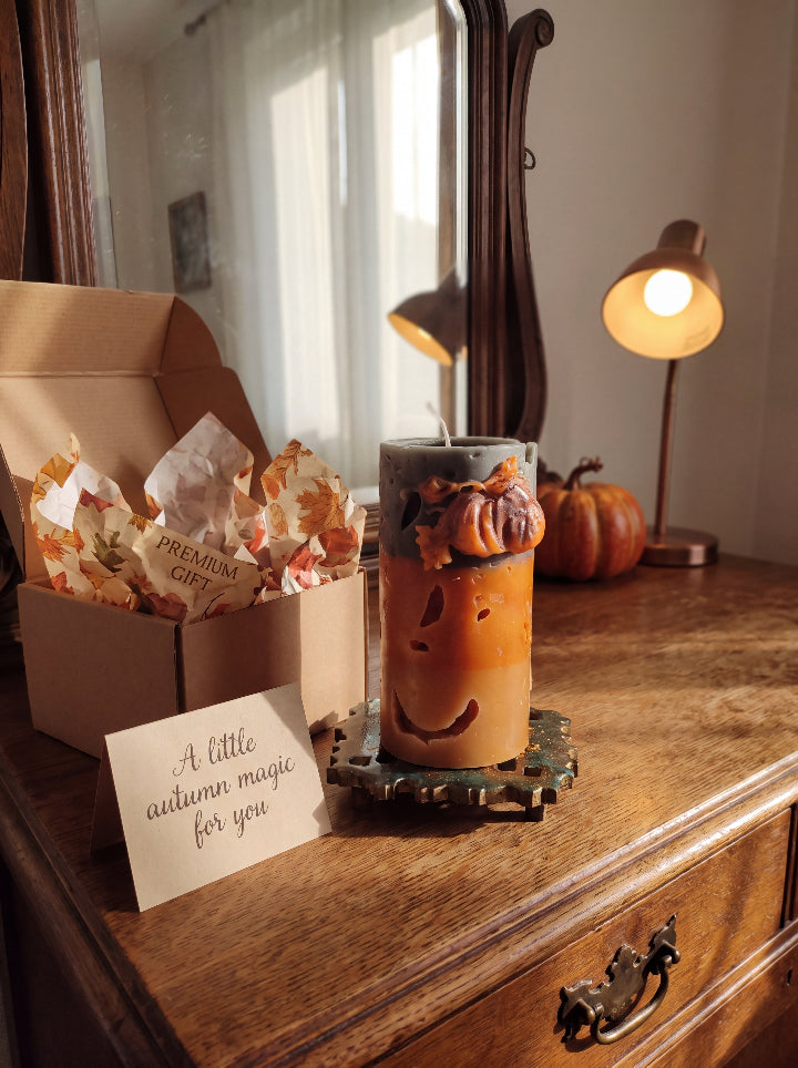 Witch’s Harvest sculptural candle beside an open gift box and an autumn greeting card.